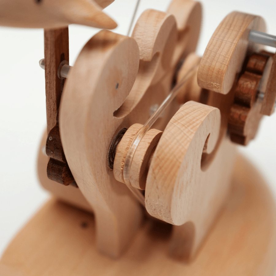 Wooden wheels and cams inside the carved waves, close up.