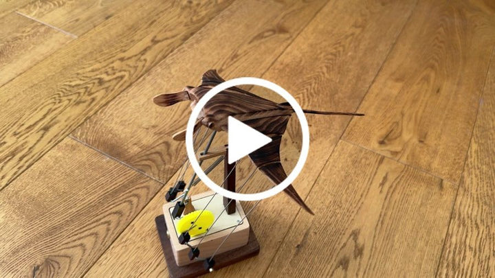 Tara D.: Manta ray automaton on its small base on a wooden floor, from an owner clip.
