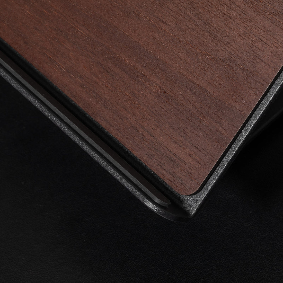Close-up of the walnut wood grain top and black metal edge