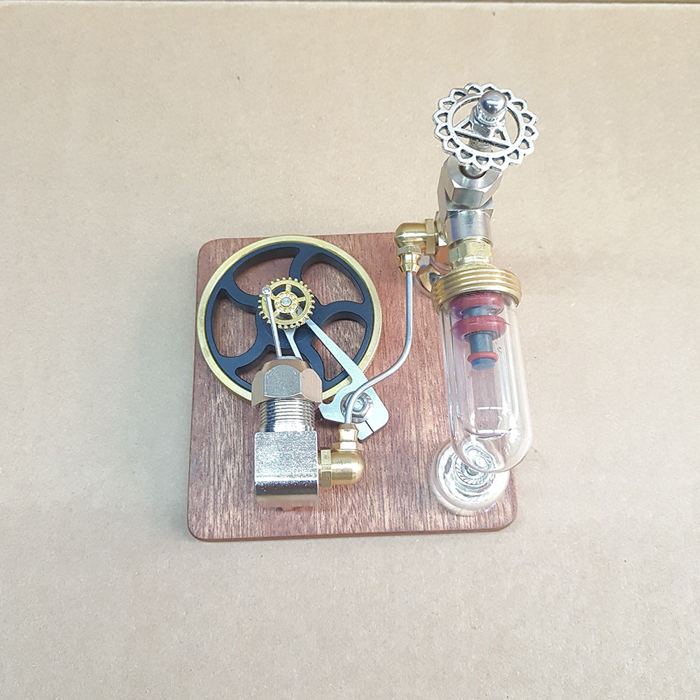 Stirling engine model from above, flywheel and glass cylinder on a small wooden base