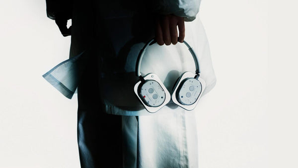 Person carrying the white Headphone (1) in one hand