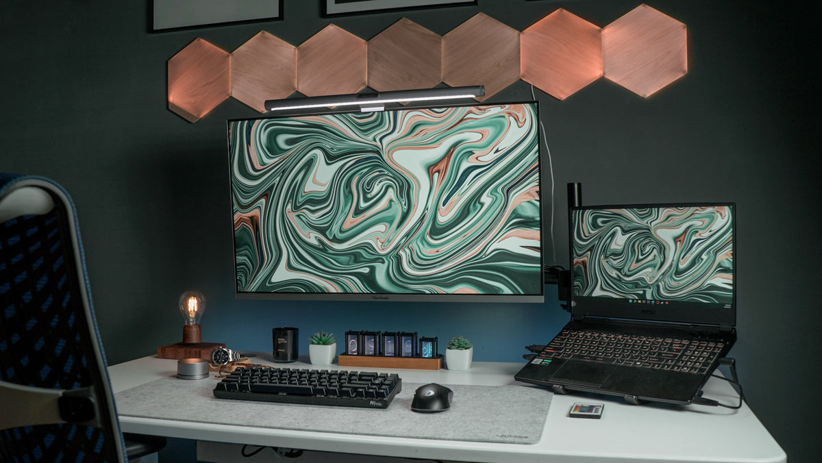 Dark teal wall desk with green marble screens, hexagon lights and a white desk