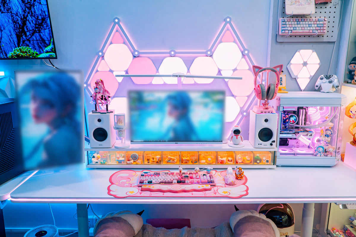 Wide view of a white desk with two monitors, a pink keyboard on a cloud desk mat and toy collections beside the PC