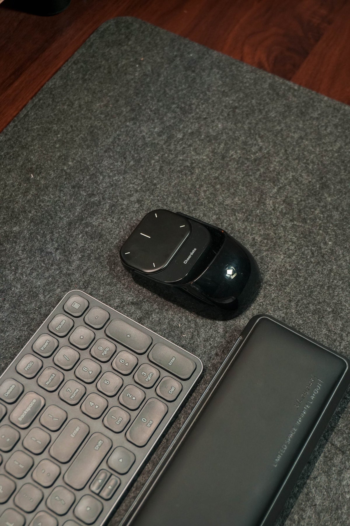 Close-up of a keyboard wrist rest and mouse on a grey felt desk mat