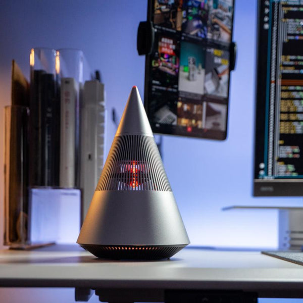 Cone speaker on a desk in front of two monitors