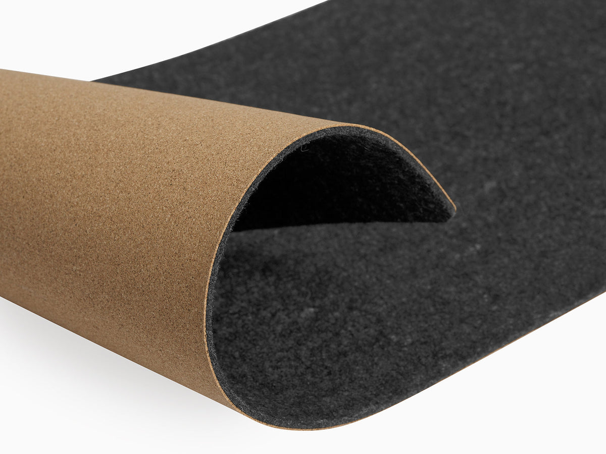 Rolled corner of the dark felt mat showing the cork base underneath