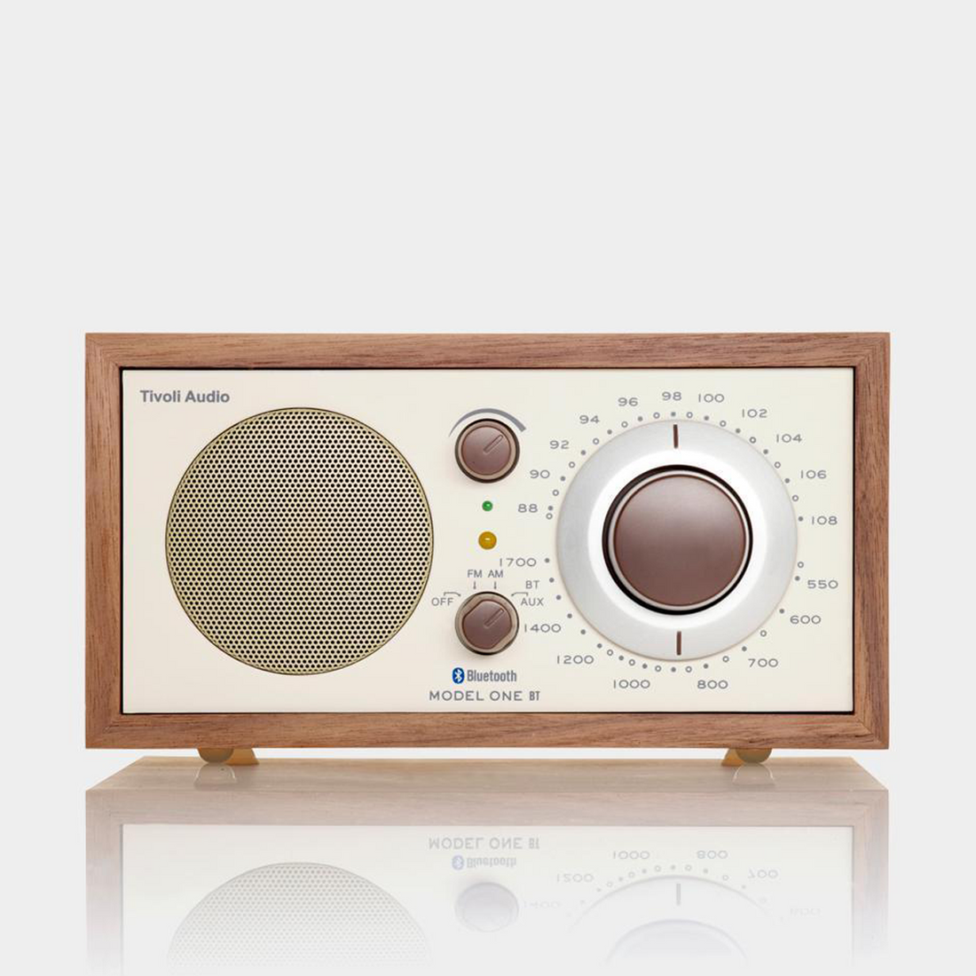 Walnut cabinet radio with a beige face, round grille and large tuning dial