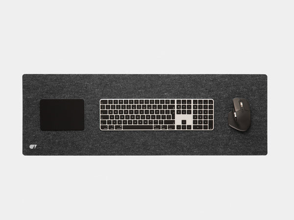 Anthracite felt desk mat from above with a keyboard, trackpad and mouse on it