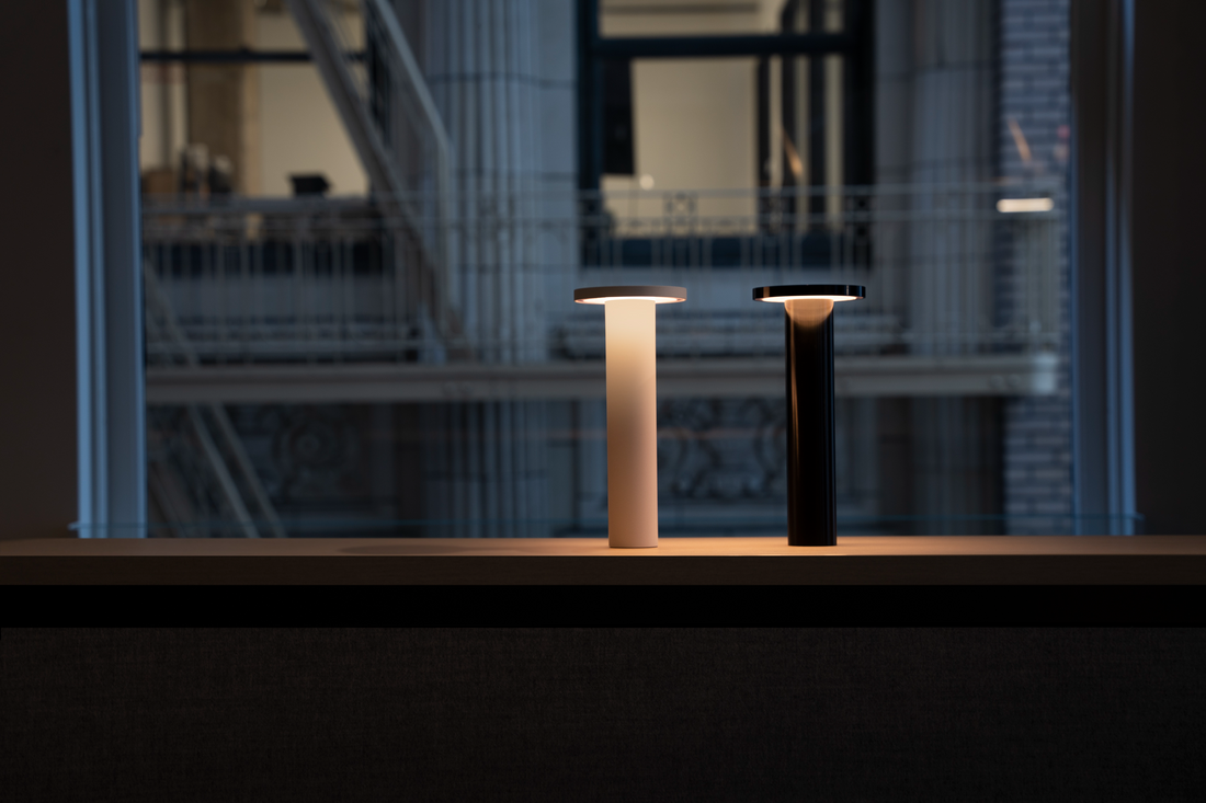 Two Luci lamps glowing warm on a windowsill ledge at dusk