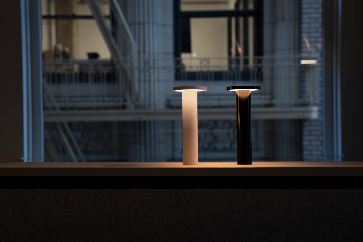 Two Luci lamps glowing warm on a windowsill ledge at dusk