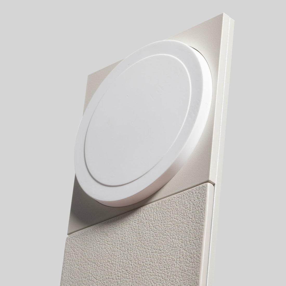 Close-up of the round magnetic pad and leather-like panel on the sandstone charger