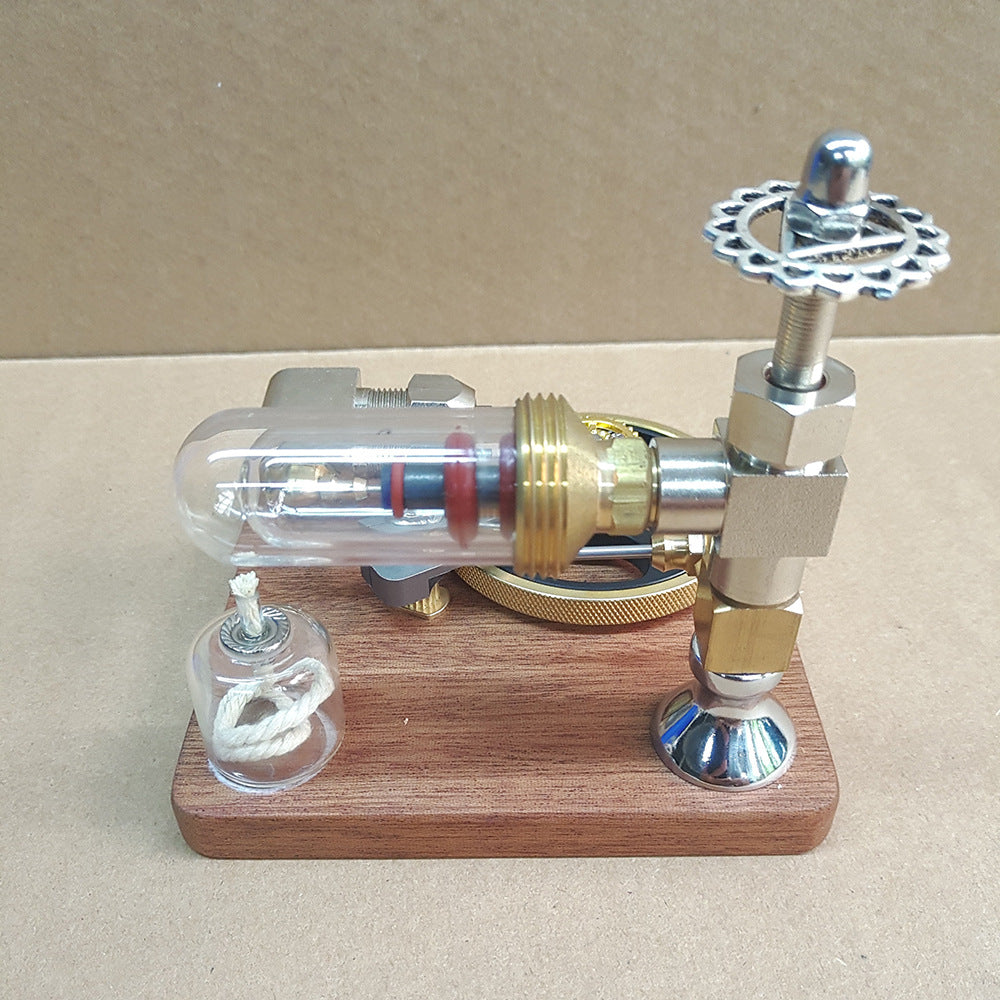 Stirling engine model from the side, glass cylinder, piston and oil lamp on a wooden base