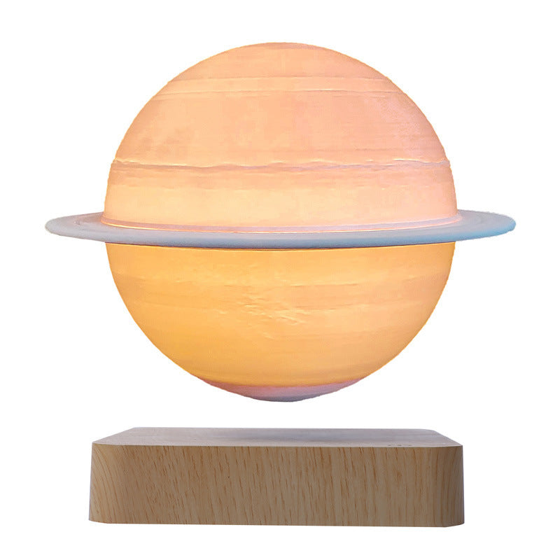 Saturn globe with its ring, lit in warm orange, floating above a light wood-grain base