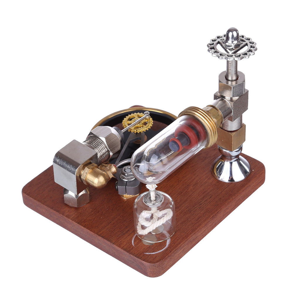 Stirling engine model on a white background, flywheel and glass cylinder visible