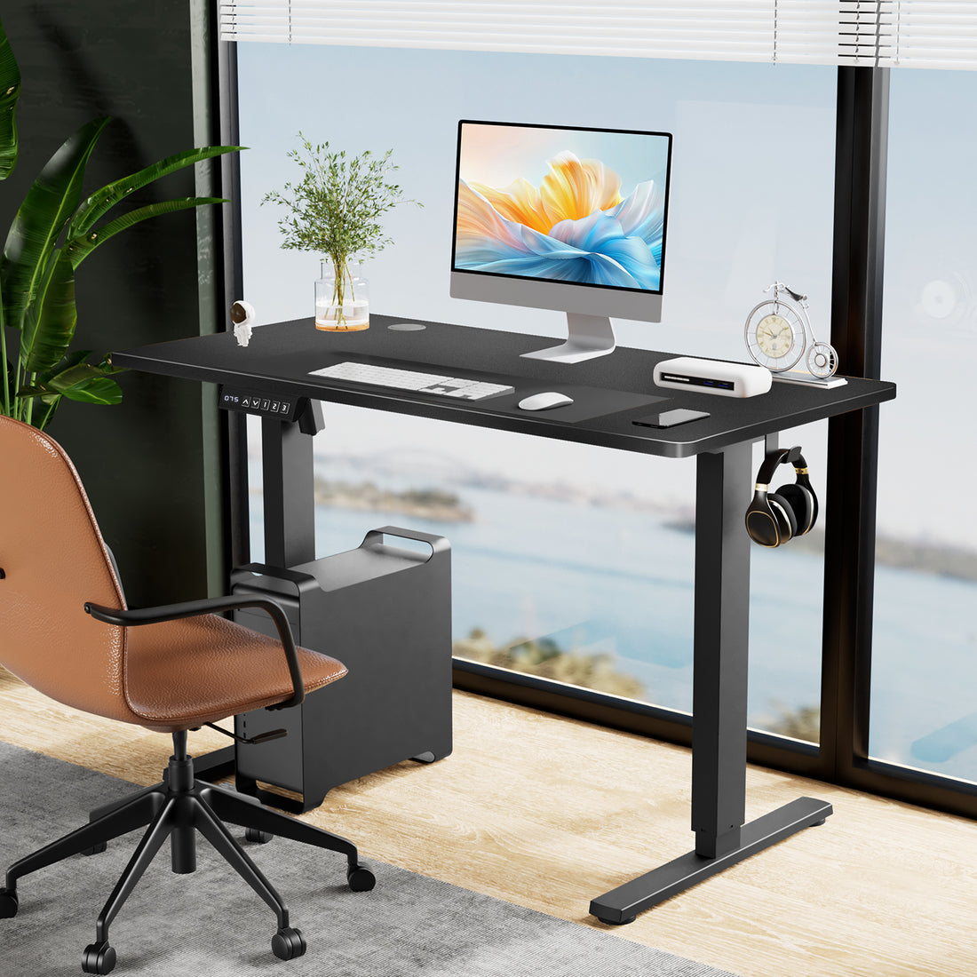 Electric Standing Desk, 63 x 24 in, black, set up by a window with a monitor and desk chair