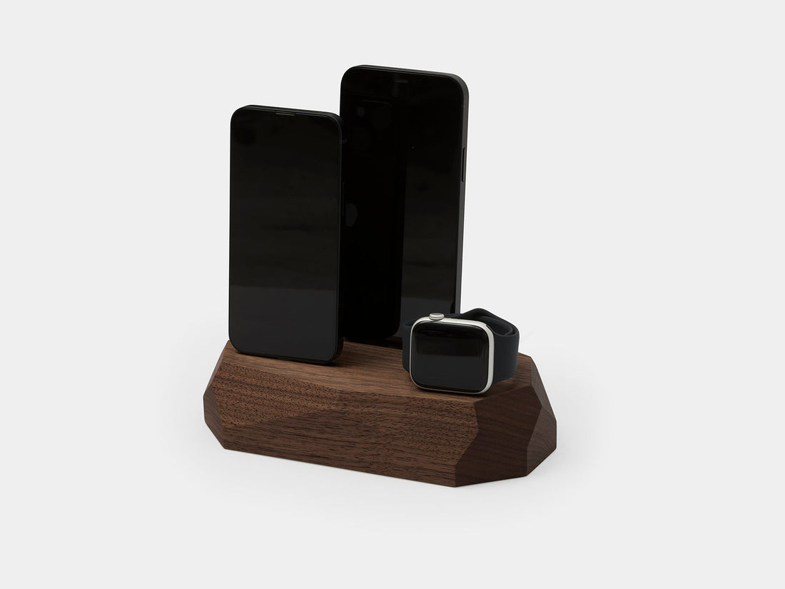 Walnut dock holding two phones and a watch