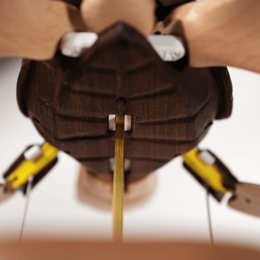 Under the shell: the brass rods, small white parts and the yellow-tipped links at the flippers.